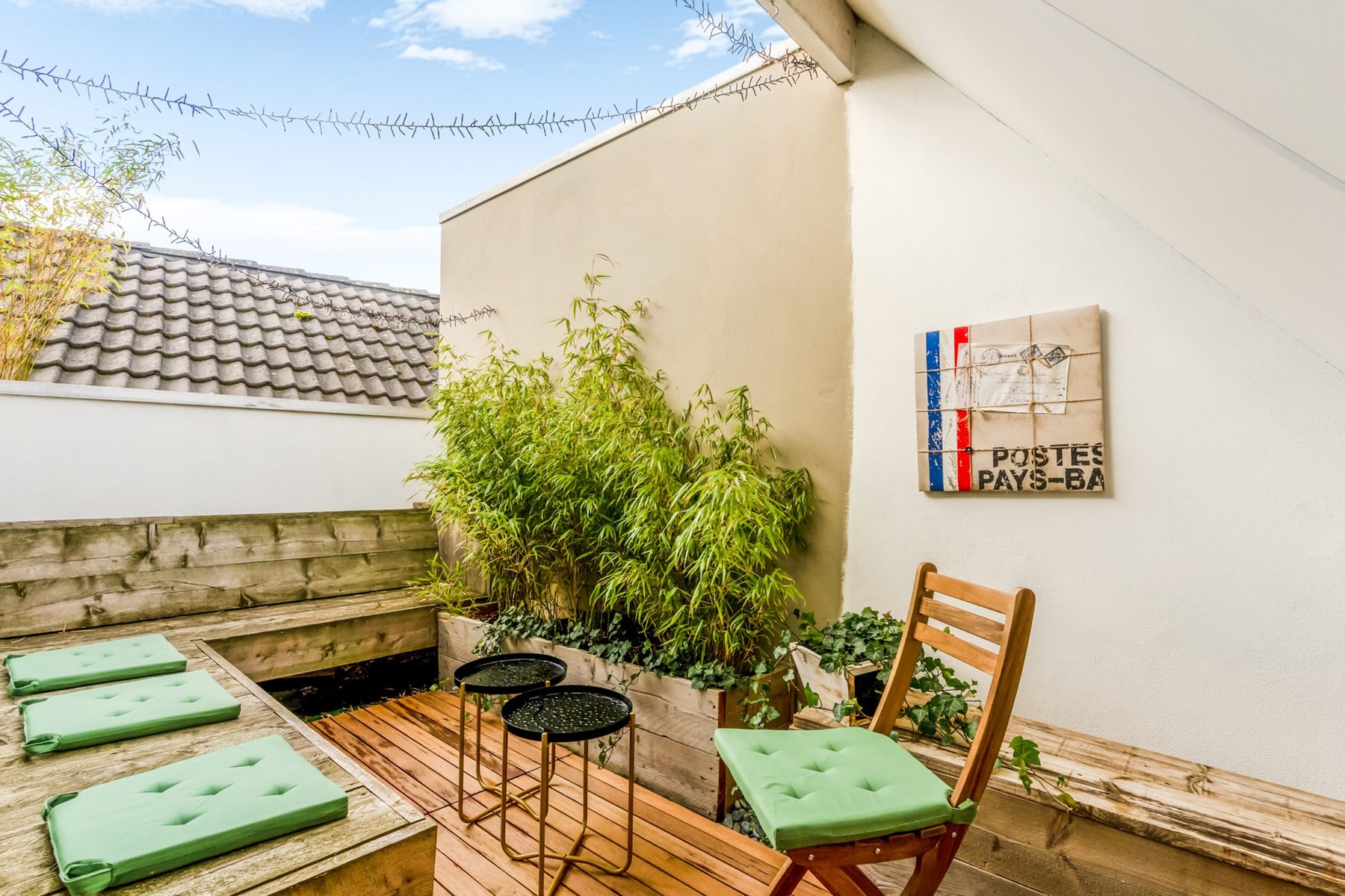 Dakterras met loungebank, kussens en plantenbakken
