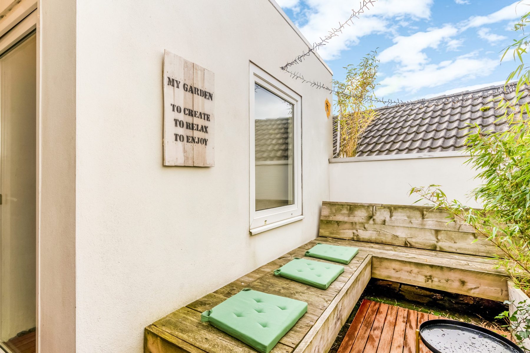 Dakterras met houten zitbank en uitzicht op de daken